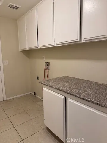 a kitchen with granite countertop a sink and a white cabinets