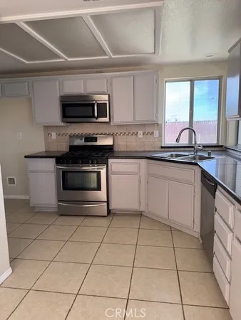a kitchen with stainless steel appliances granite countertop a sink and a stove