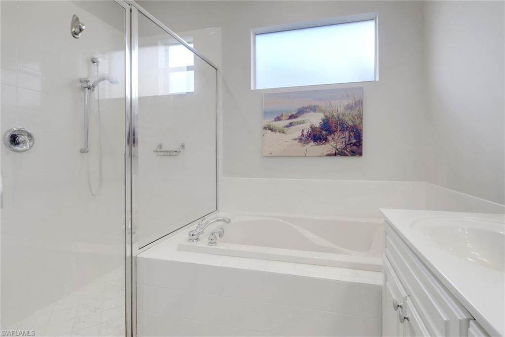 6757 Bent Grass Drive Naples, FL 34113 - Photo 15 of 27 a bathroom with a tub and a shower