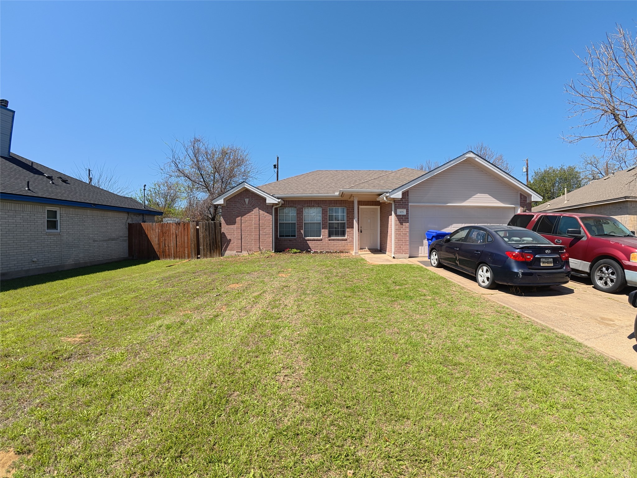 305 China Cove Elgin, TX 78621 - Photo 2 of 19 a front view of a house with a yard and garage
