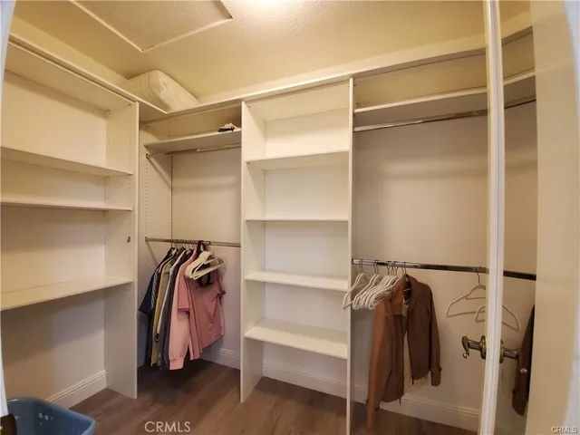 a view of walk in closet with clothes and shoes