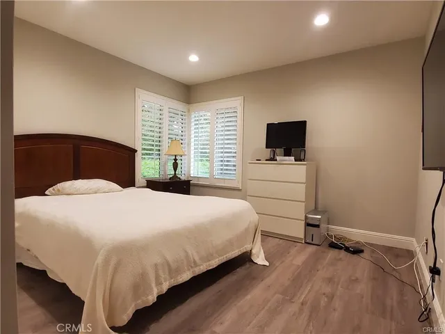 a bedroom with a bed and a flat tv screen on the dresser
