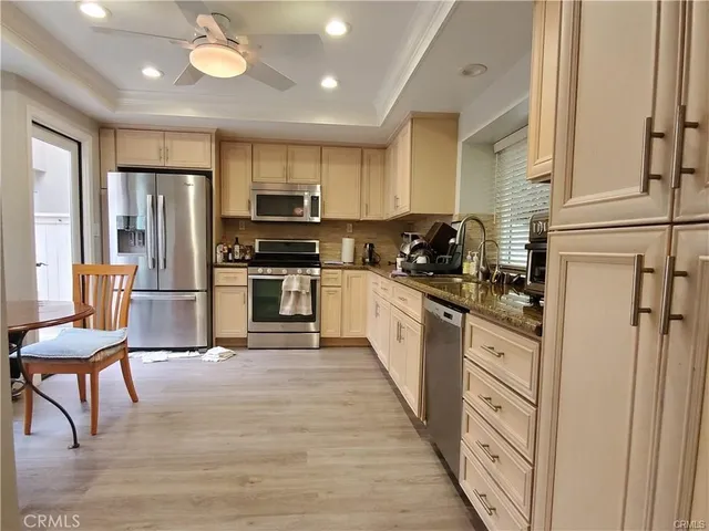 a kitchen with stainless steel appliances granite countertop a refrigerator stove microwave and cabinets