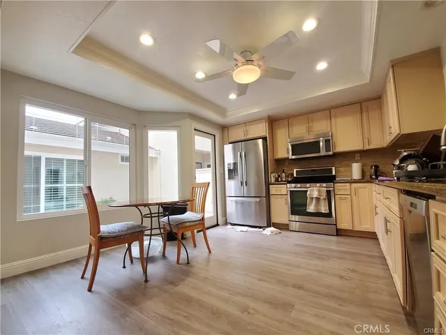 a kitchen with microwave a refrigerator and chairs