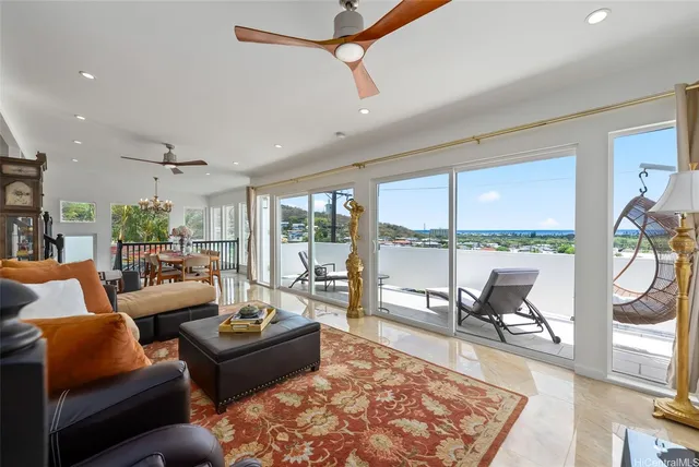a living room with furniture large windows and wooden floor