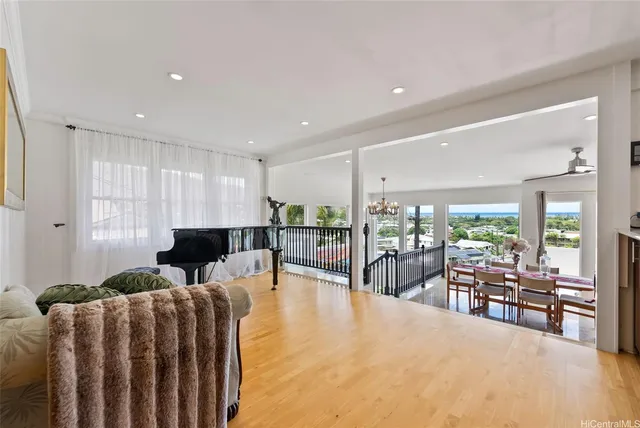 a living room with furniture a large window and flat screen tv