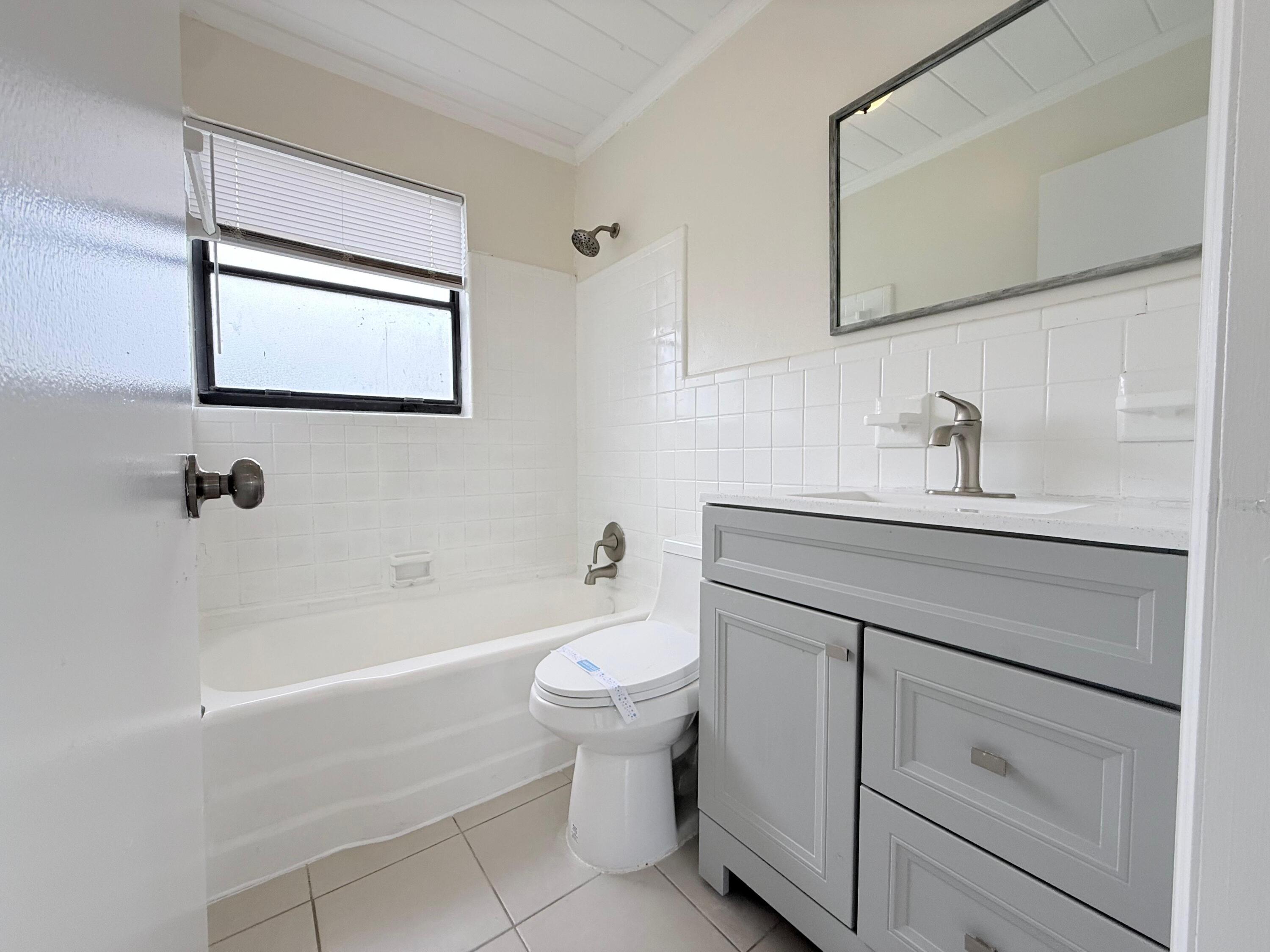 1409 West 33rd Street, Unit 1 Riviera Beach, FL 33404 - Photo 2 of 13 a bathroom with a sink a toilet and bathtub