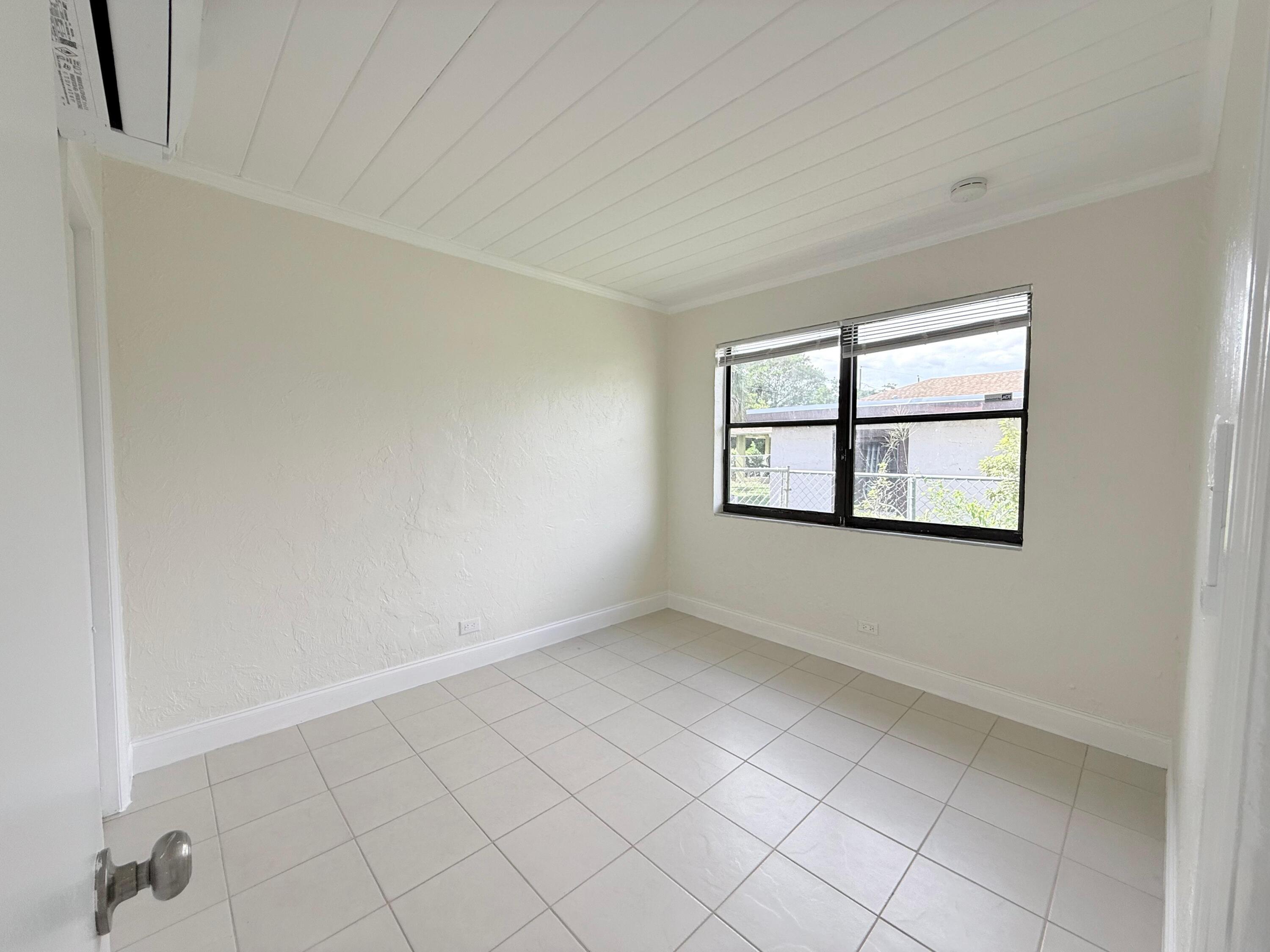 1409 West 33rd Street, Unit 1 Riviera Beach, FL 33404 - Photo 4 of 13 an empty room with windows
