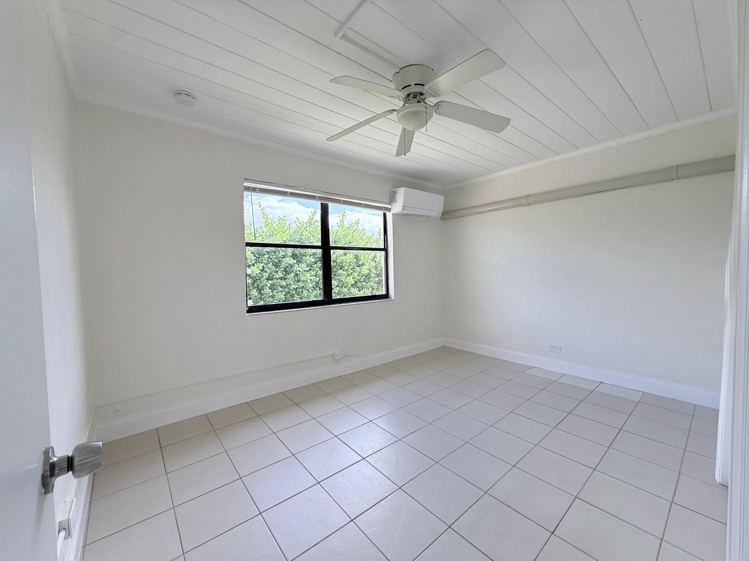 1409 West 33rd Street, Unit 1 Riviera Beach, FL 33404 - Photo 9 of 13 an empty room with windows and fan