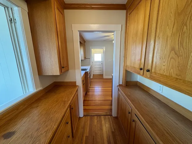 a view of a hallway with wooden floor and staircase