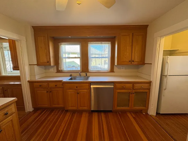 a kitchen with wooden floors and white appliances