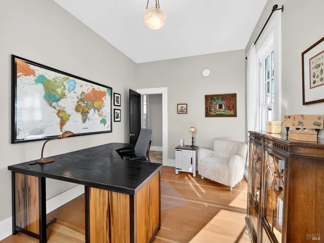 a living room with furniture a couch and paintings on the wall