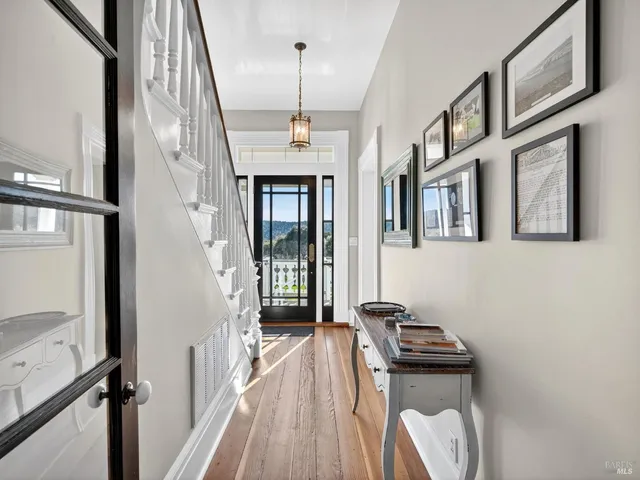 a view of a hallway with wooden floor and staircase
