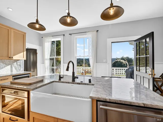a kitchen with stainless steel appliances granite countertop a sink a stove and a wooden floors