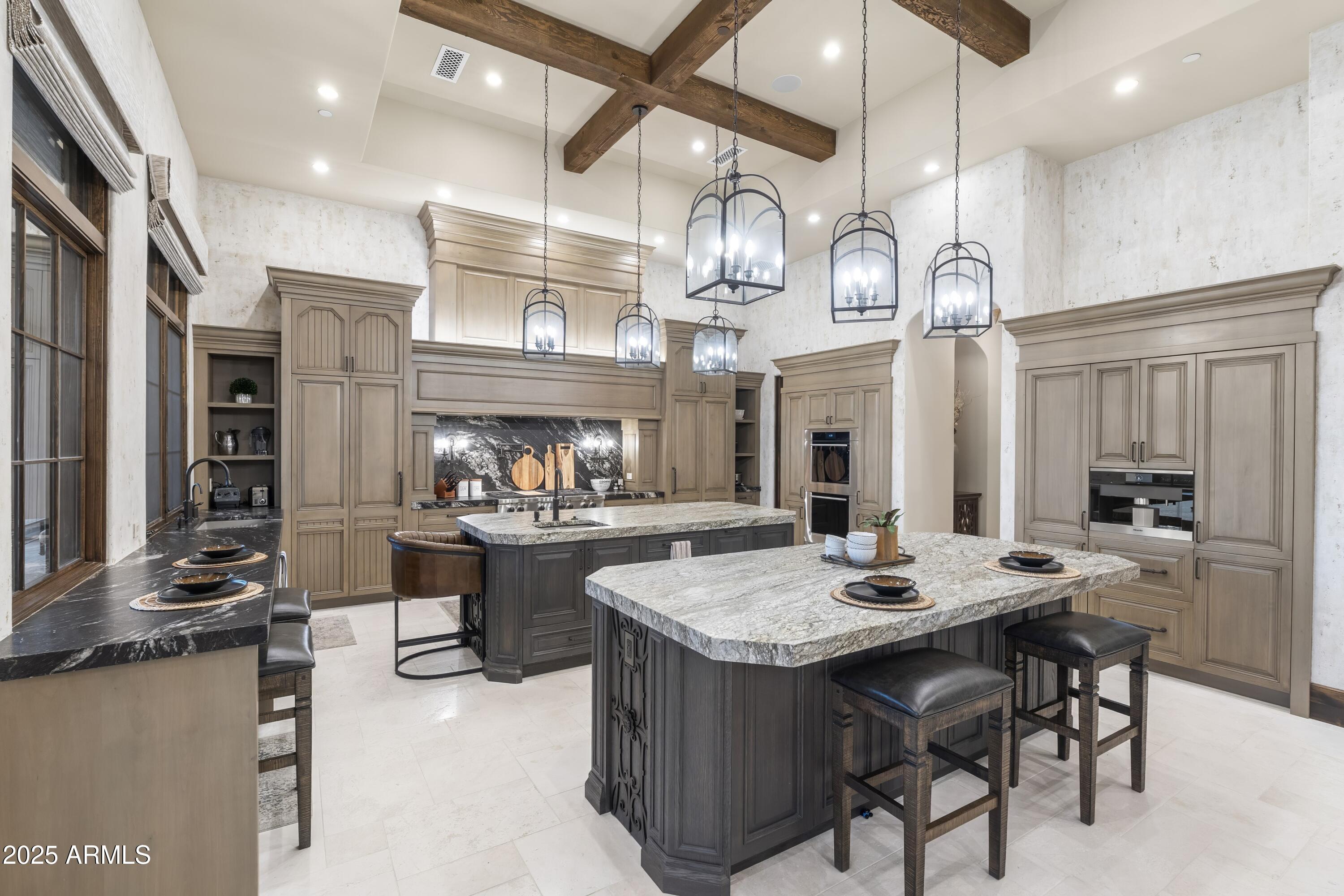 14699 East Paradise Drive, Unit 26 Scottsdale, AZ 85259 - Photo 41 of 73 a kitchen with stainless steel appliances kitchen island granite countertop a table chairs and a chandelier