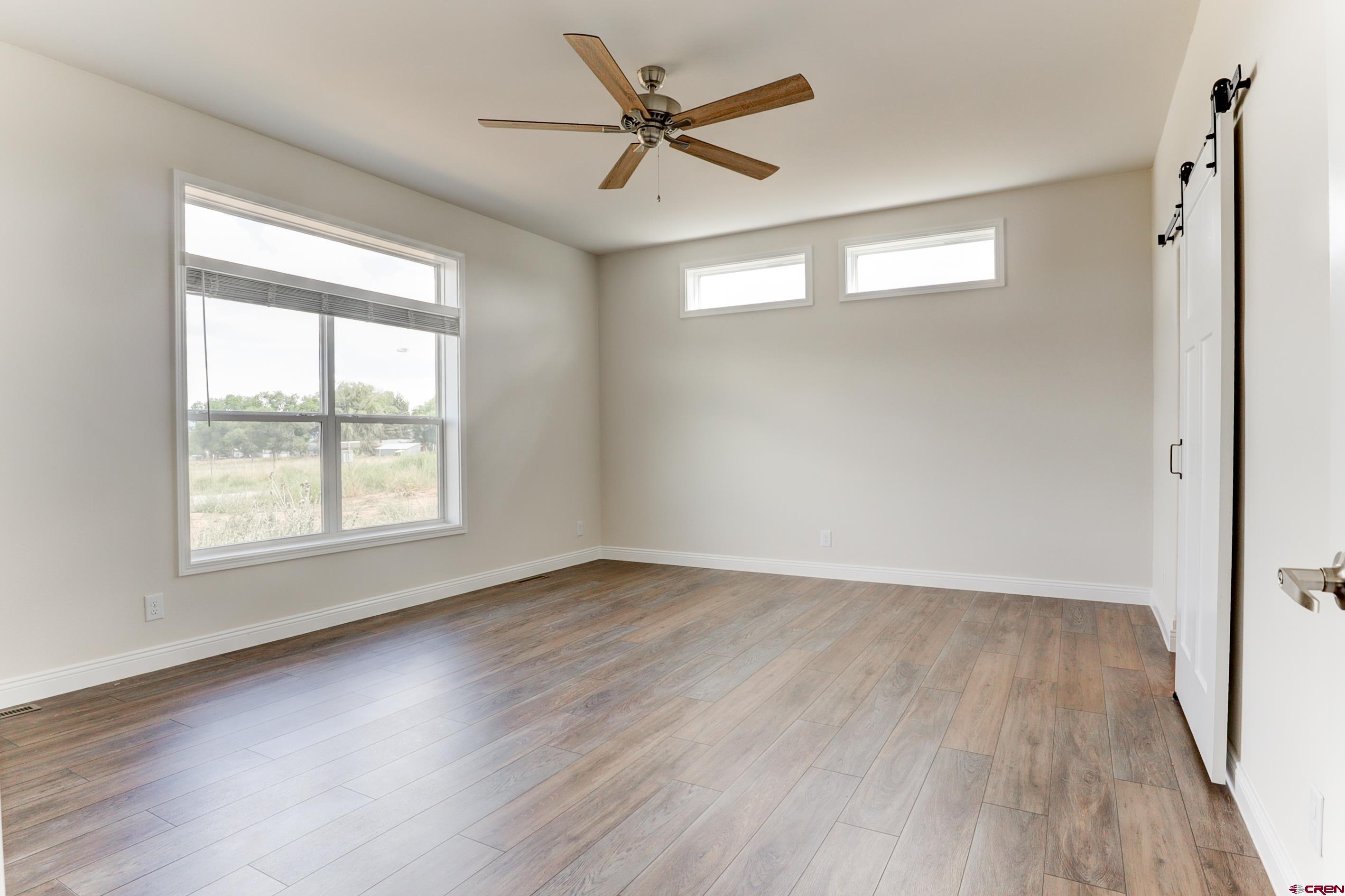 22667 Rd L Cortez, CO 81321 - Photo 12 of 35 a view of an empty room with wooden floor and a window