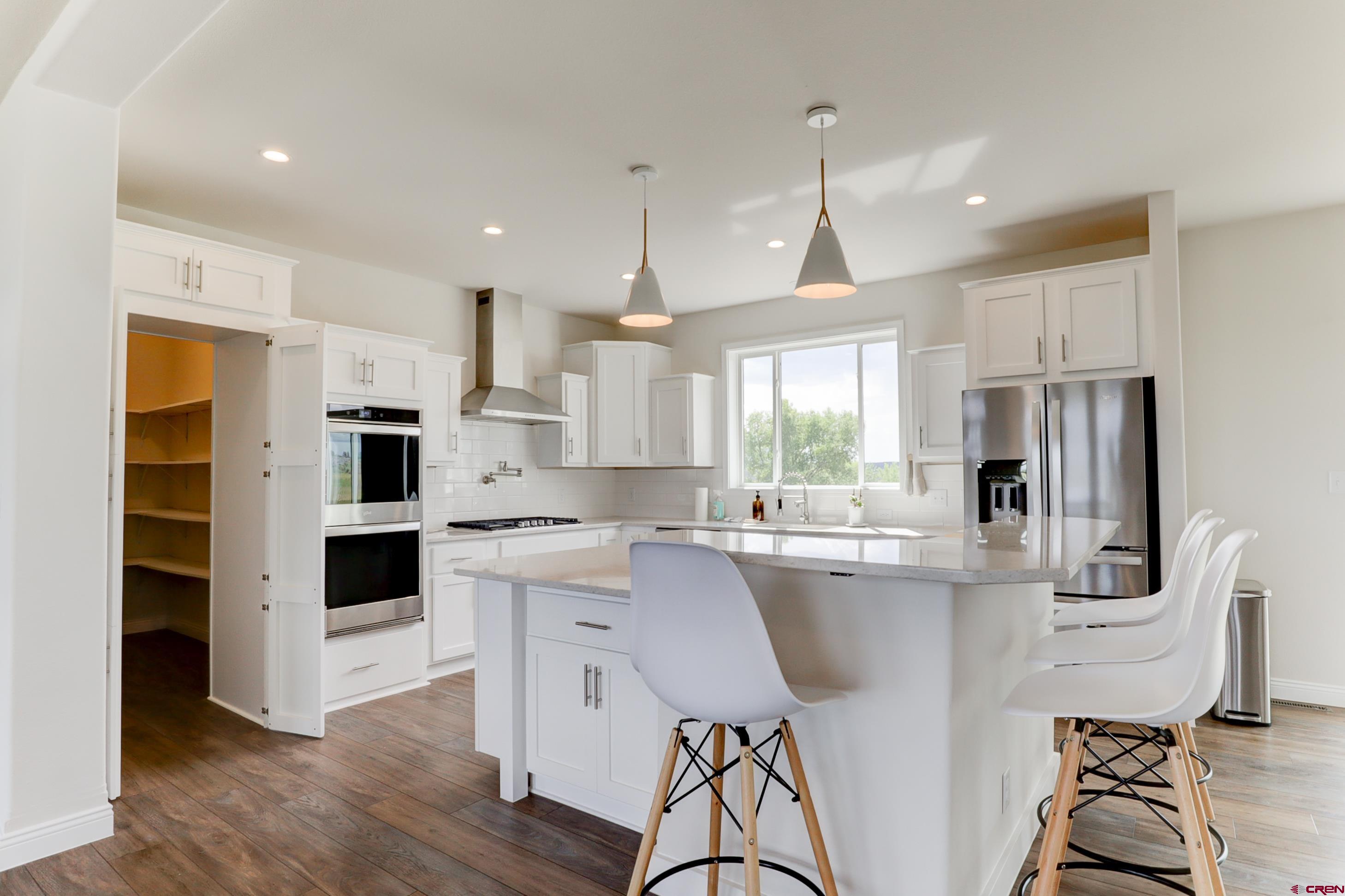 22667 Rd L Cortez, CO 81321 - Photo 2 of 35 a kitchen with kitchen island a stove a sink a refrigerator and a dining table