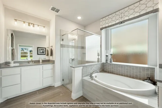 a bathroom with a tub a sink and a large mirror