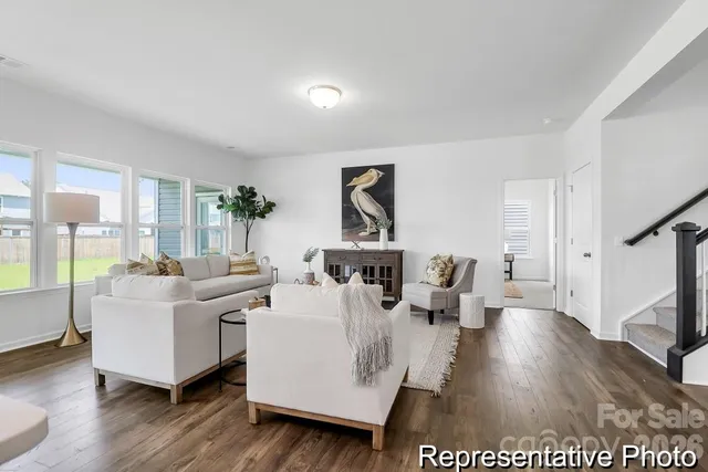 a living room with furniture wooden floor and a large window