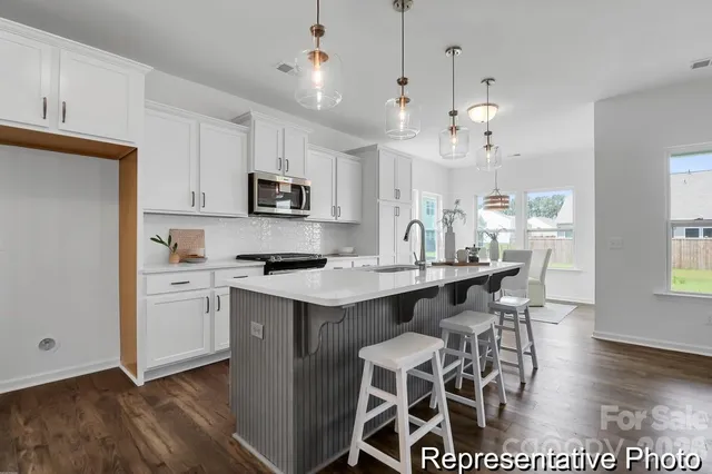 a kitchen with a dining table chairs and white cabinets