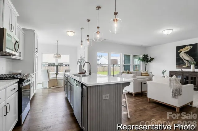 a kitchen with lots of counter top space a sink appliances and cabinets