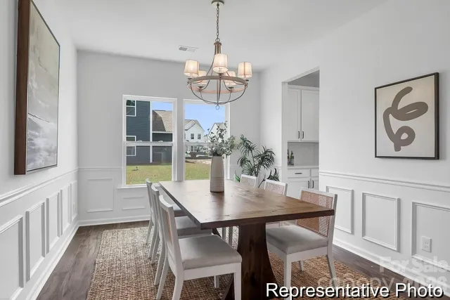 a view of a dining room with furniture a chandelier and wooden floor