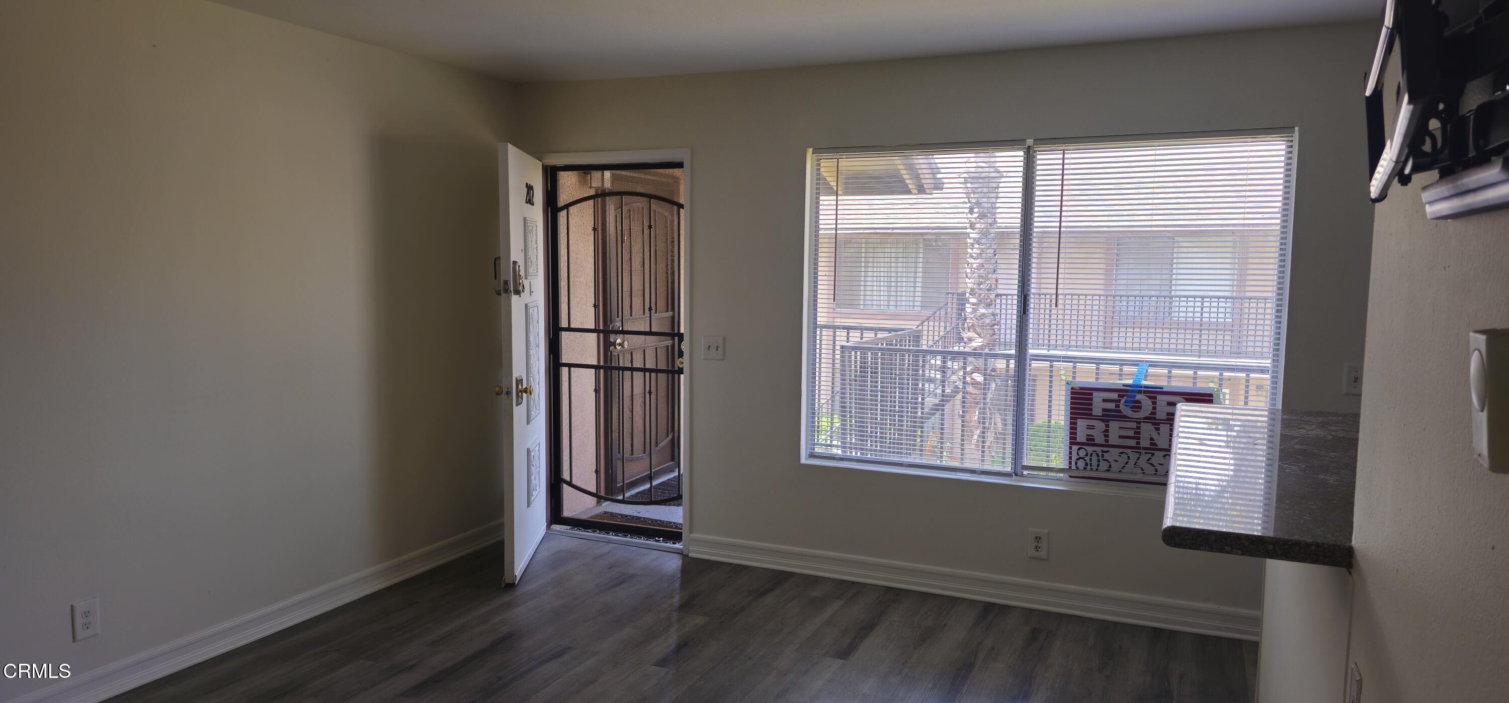1925 Ginger Street, Unit 202 Oxnard, CA 93036 - Photo 5 of 6 an empty room with wooden floor and windows