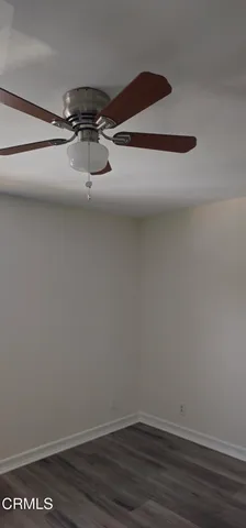 a view of a room with wooden floor and ceiling fan