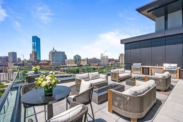a view of a roof deck with couches and potted plants
