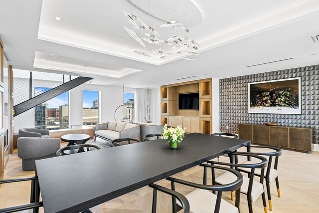 a living room with furniture a chandelier and a flat screen tv