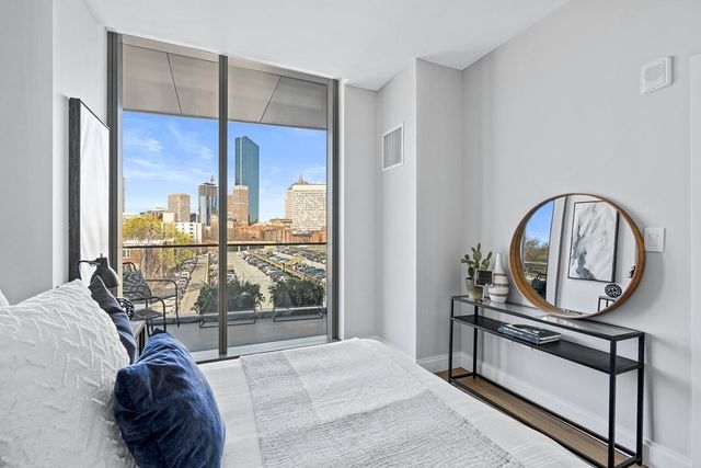 a living room with a large window and a chandelier