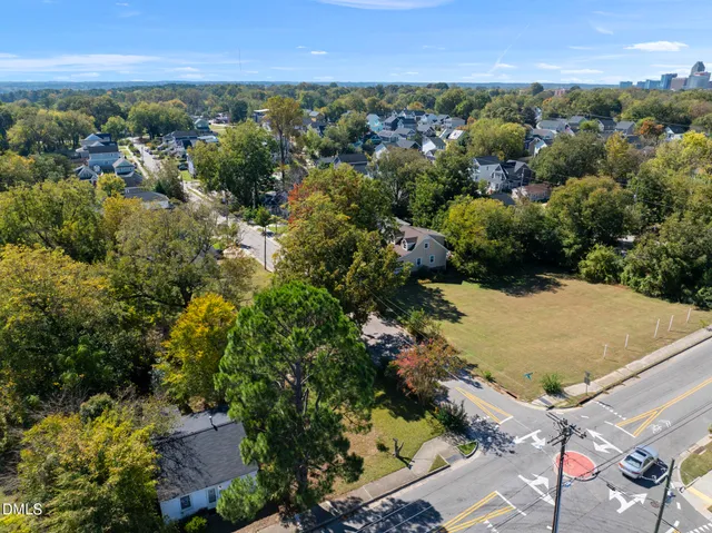 an aerial view of residential houses with outdoor space and trees