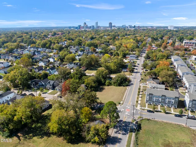 an aerial view of residential houses with outdoor space and trees