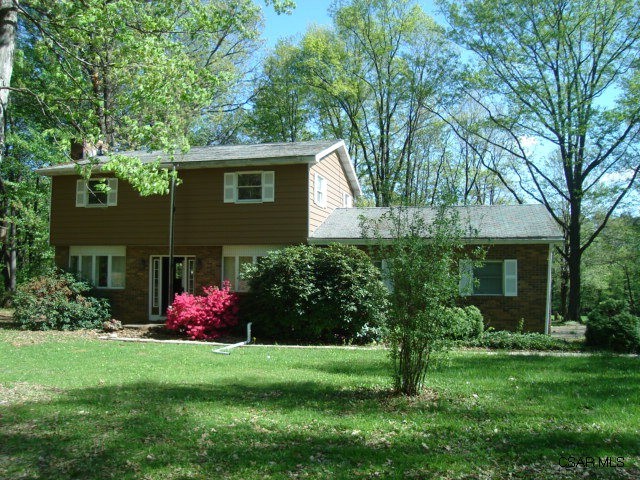 a view of a house with a yard and a garden