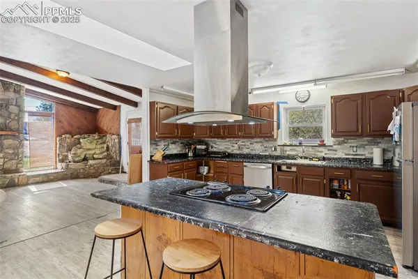 a kitchen with stainless steel appliances granite countertop a stove a sink and a microwave