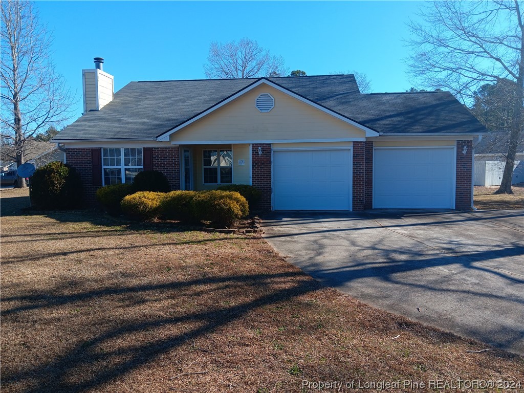 517 Woodwind Drive Spring Lake, NC 28390 - Photo 1 of 32 a front view of a house with garden