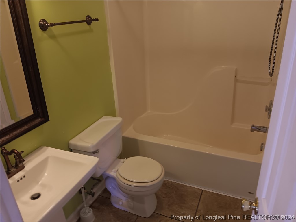 517 Woodwind Drive Spring Lake, NC 28390 - Photo 17 of 32 a white toilet sitting next to a bathroom sink