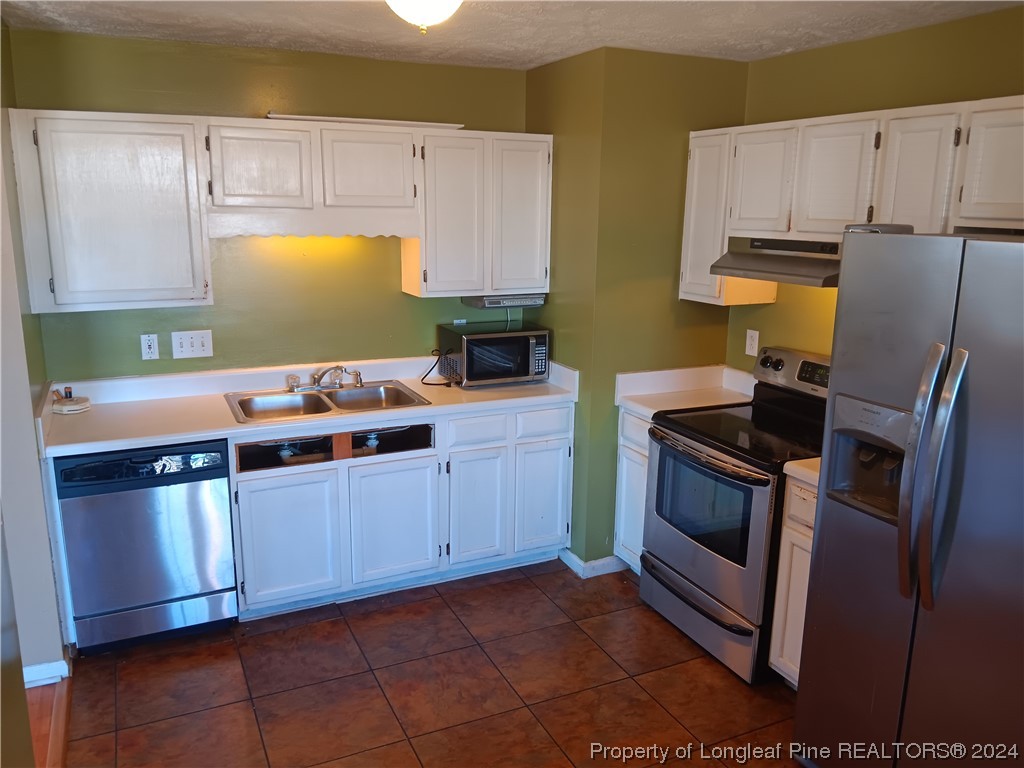 517 Woodwind Drive Spring Lake, NC 28390 - Photo 21 of 32 a kitchen with stainless steel appliances a stove a sink and a microwave