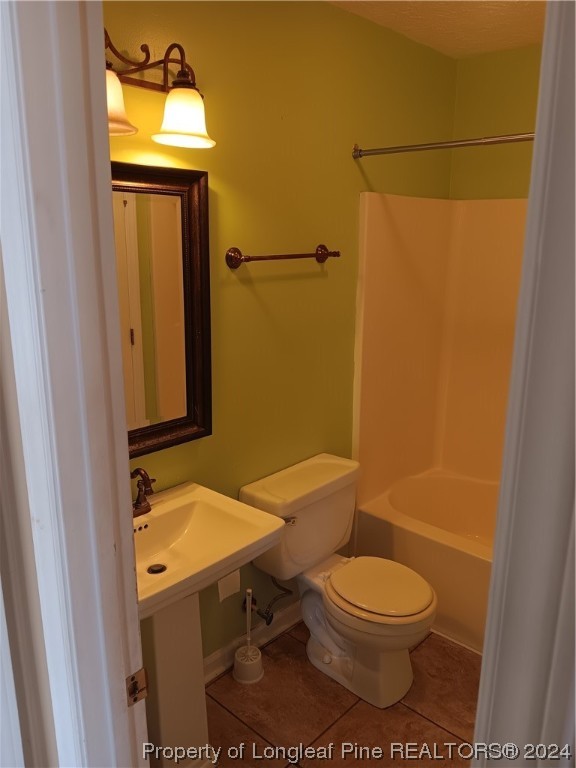 517 Woodwind Drive Spring Lake, NC 28390 - Photo 26 of 32 a bathroom with a toilet a sink and mirror