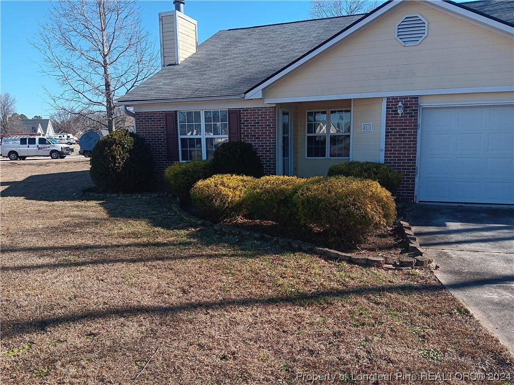 517 Woodwind Drive Spring Lake, NC 28390 - Photo 10 of 32 a view of a house with a yard and garage