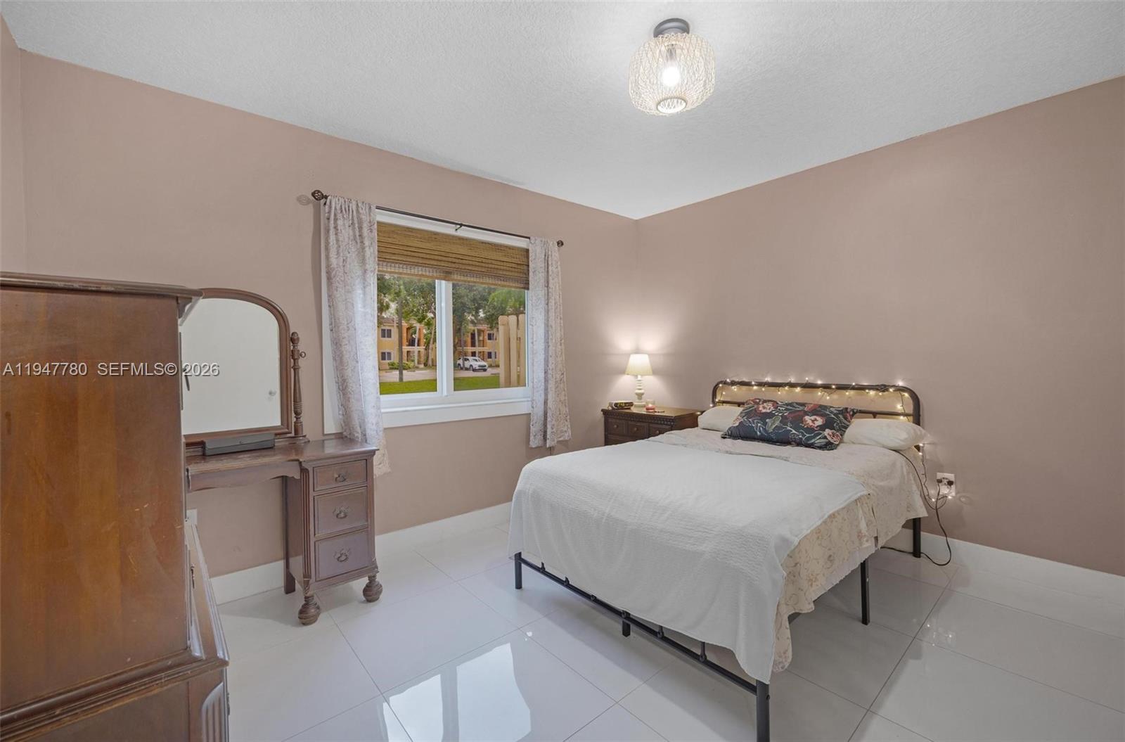 985 Northeast 33rd Terrace, Unit 102 Homestead, FL 33033 - Photo 13 of 20 a bedroom with a bed and a windows