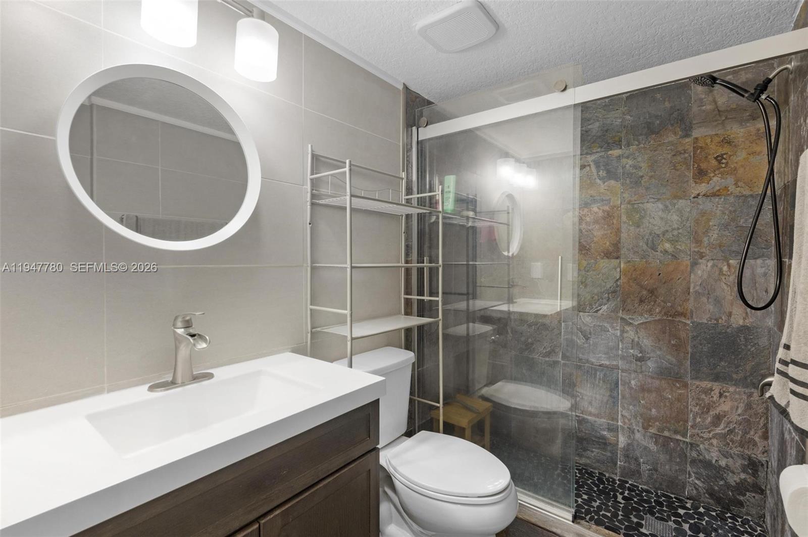 985 Northeast 33rd Terrace, Unit 102 Homestead, FL 33033 - Photo 14 of 20 a bathroom with a sink a toilet and shower