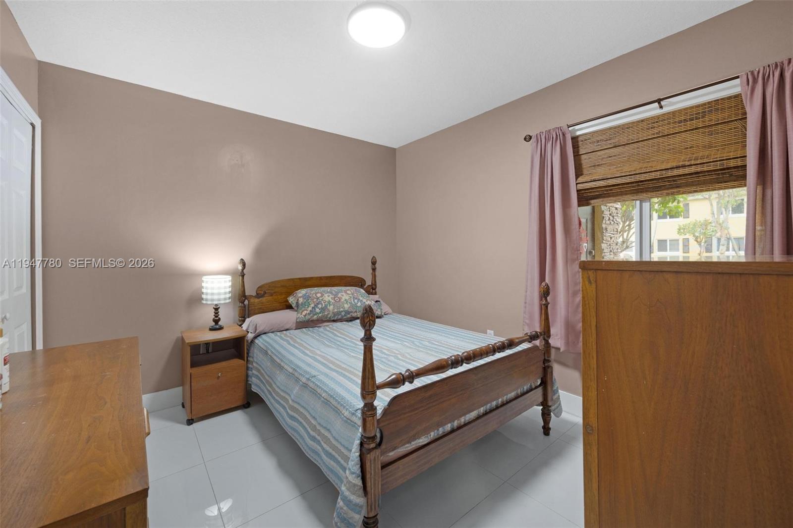 985 Northeast 33rd Terrace, Unit 102 Homestead, FL 33033 - Photo 15 of 20 a bed sitting in a bedroom next to a window