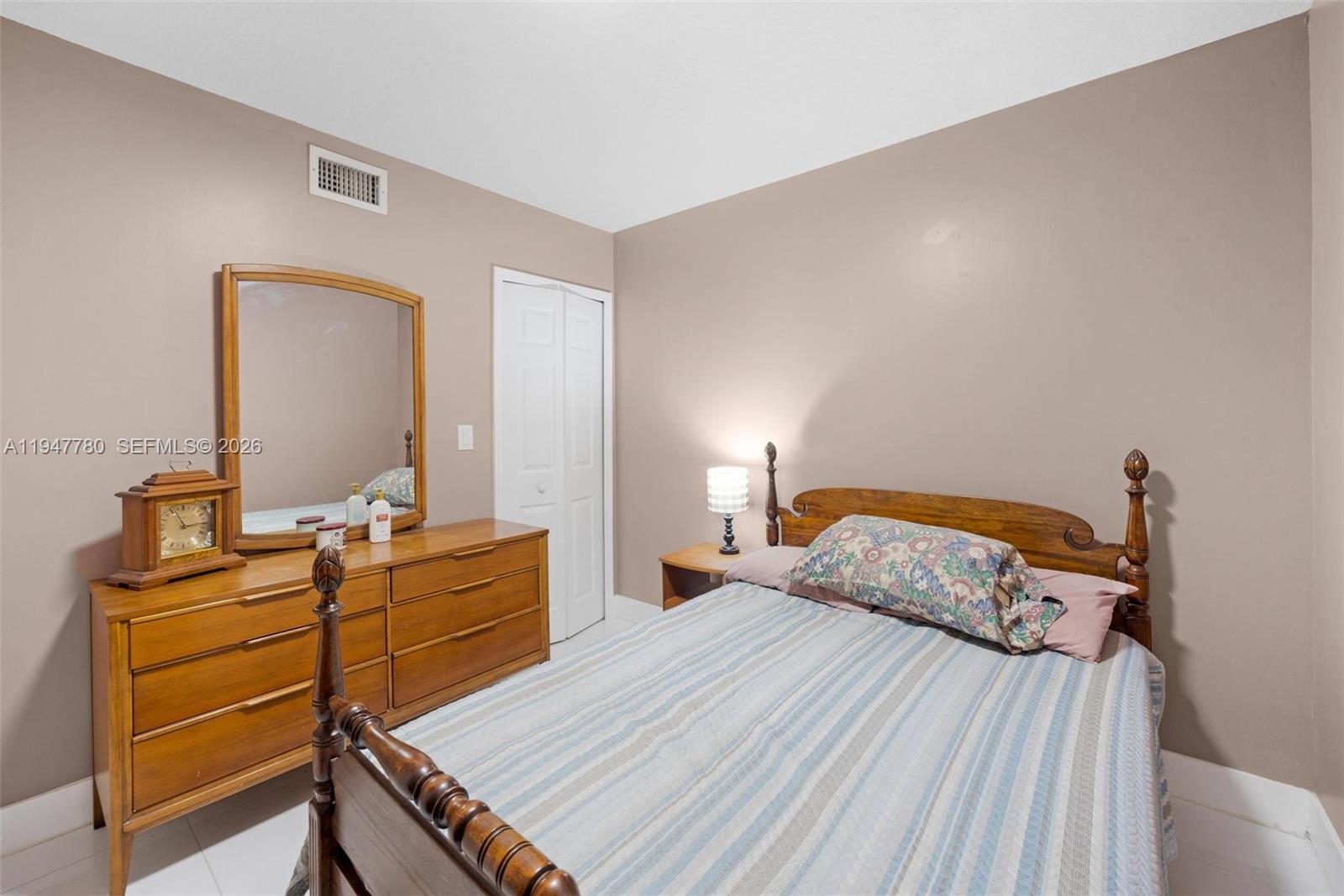 985 Northeast 33rd Terrace, Unit 102 Homestead, FL 33033 - Photo 16 of 20 a bedroom with a bed and dresser