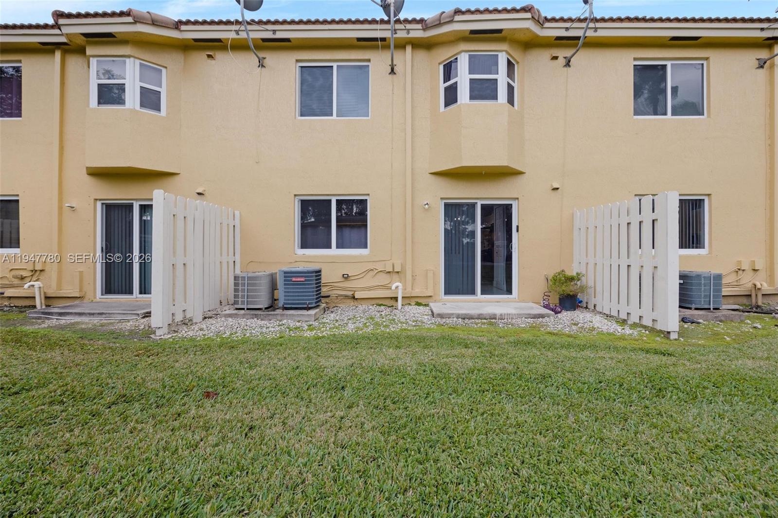 985 Northeast 33rd Terrace, Unit 102 Homestead, FL 33033 - Photo 18 of 20 a house that has a big yard in front of it