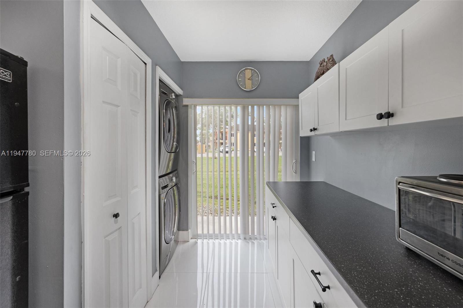 985 Northeast 33rd Terrace, Unit 102 Homestead, FL 33033 - Photo 9 of 20 a kitchen with granite countertop a refrigerator and a stove