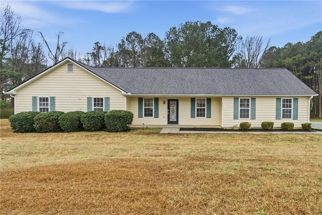 a front view of a house with a garden and yard