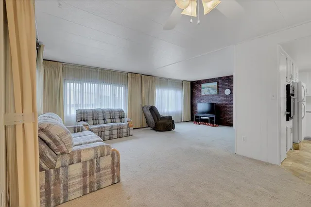 a living room with furniture a window and a flat screen tv