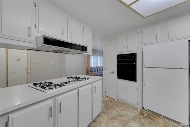 a kitchen with stainless steel appliances a refrigerator stove and white cabinets