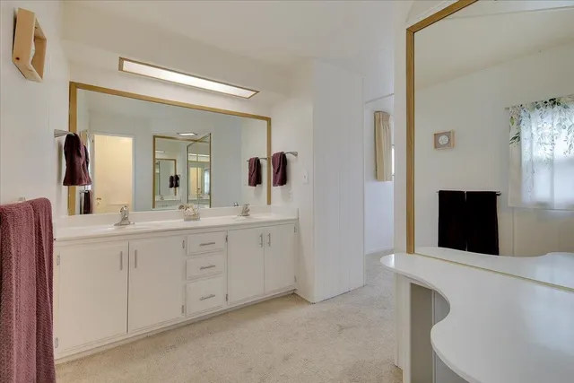 a spacious bathroom with a double vanity sink and mirror